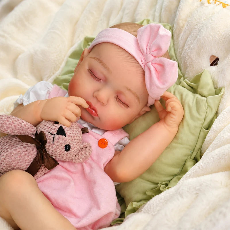 Pink Bow sleeping reborn baby doll closed eyes with painted eyebrows, rooted hair, glossy lips, curled fingers