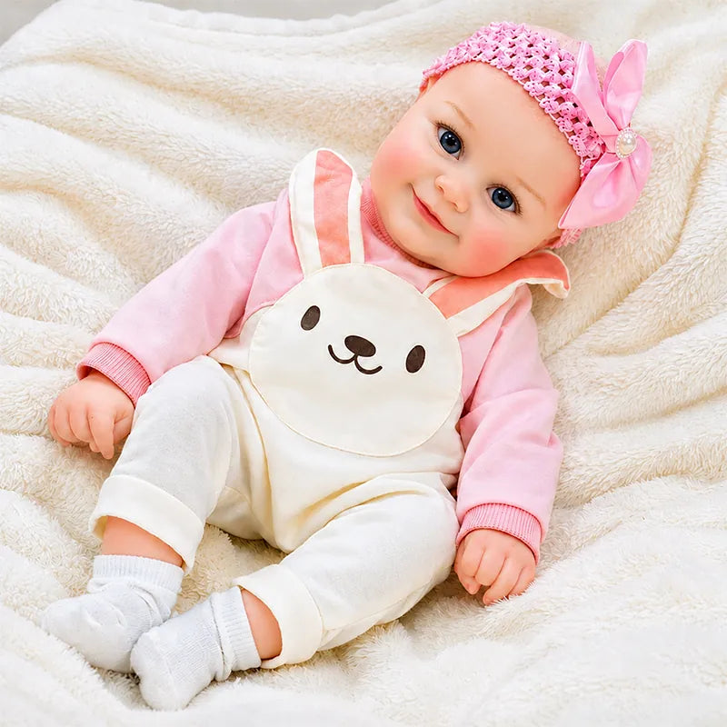 Realistic reborn baby doll with bright blue eyes, a gentle smile, and lifelike infant features.