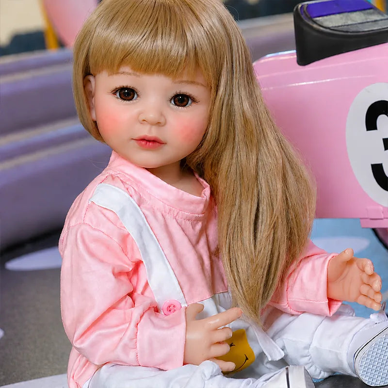 Sweet blonde reborn doll with a gentle expression, poseable limbs, realistic hands, and a fashionable pink-and-white outfit.