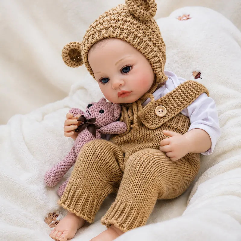 Charming reborn baby doll in a knitted bear romper, making a thoughtful birthday, Christmas, or collector’s gift.