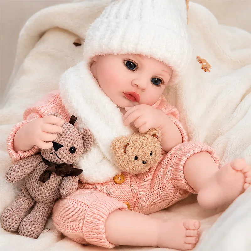 reborn baby doll sitting on a cozy nursery blanket with her teddy bear, perfect for pretend play, photography, and display.