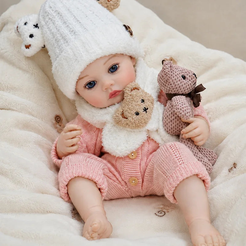 lifelike reborn baby doll with bright blue eyes, realistic facial details, and a soft pink knitted outfit.