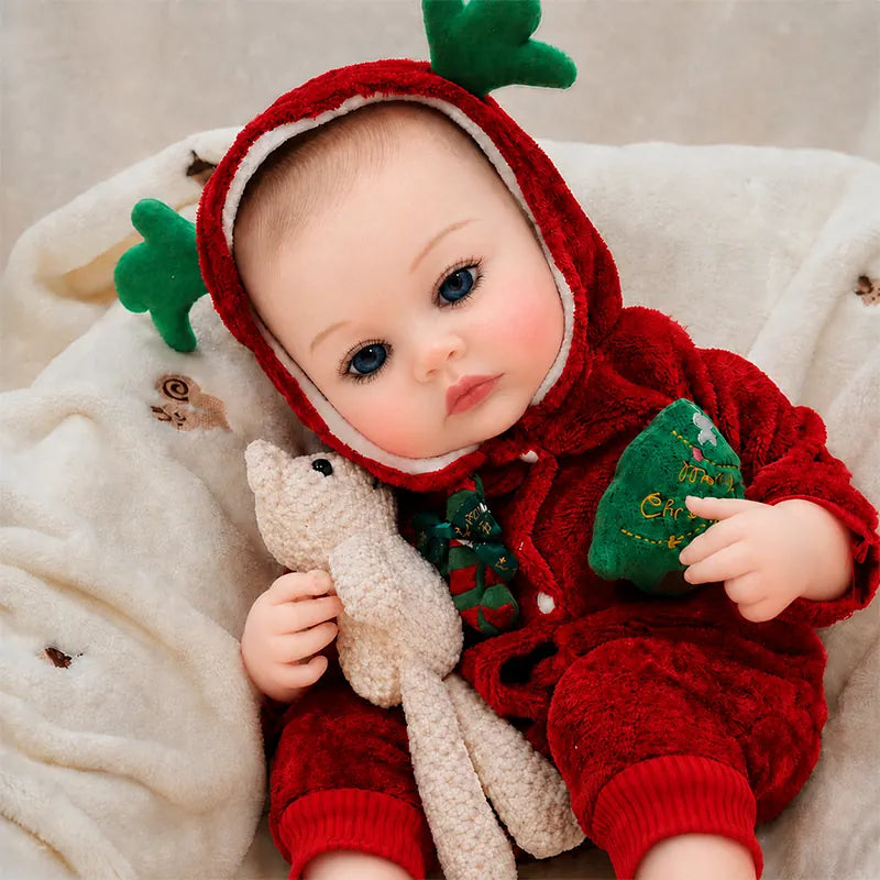Lifelike reborn baby doll with bright blue eyes, rosy cheeks, realistic skin tones, and an adorable Christmas costume.