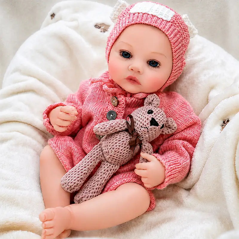 Realistic reborn doll with bright blue eyes, delicate eyelashes, rosy cheeks, and finely painted baby skin details.