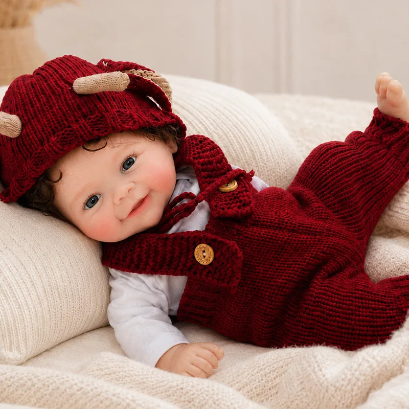 Full Silicone Reborn Baby Doll sitting comfortably in a cozy knitted chair for nursery display and pretend play.