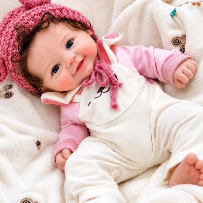 Full Silicone Reborn Baby Doll with a Pink Knitted Hat, Bunny Overalls, Blue Eyes, and a Cheerful Smile