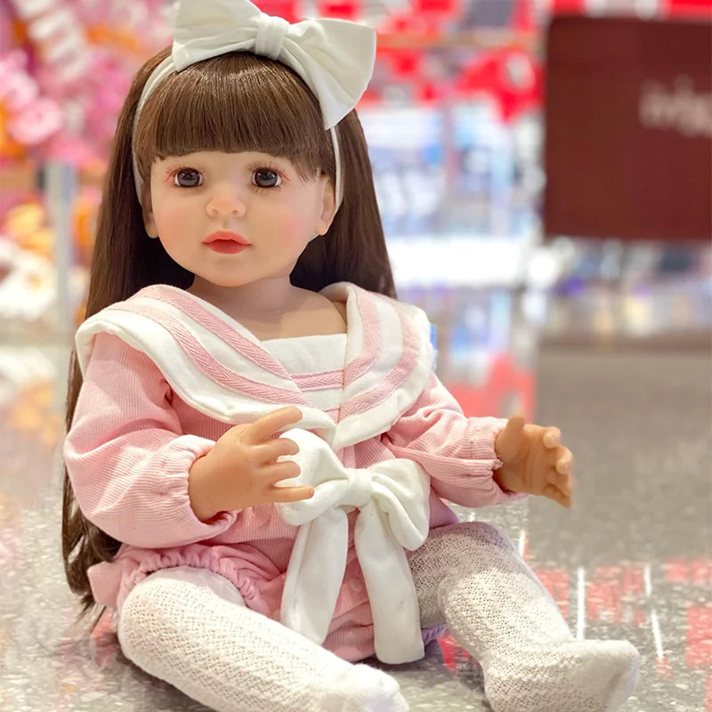 Realistic reborn toddler doll featuring bright eyes, delicate eyelashes, softly blushed cheeks, and natural pink lips.