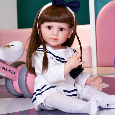 Sophie lifelike doll dressed in a navy-and-white sailor outfit, lace stockings, and a matching bow headband.