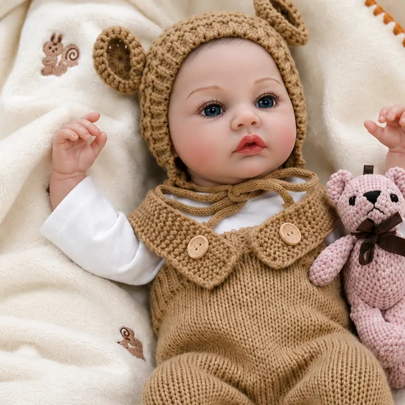 Realistic reborn baby doll with bright blue eyes, rosy cheeks, delicate eyelashes, and lifelike hand-painted facial details.
