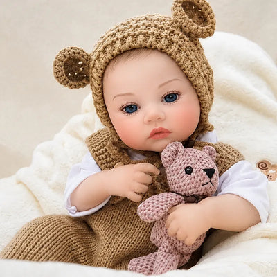Adorable open-eyed reborn baby doll dressed as a little bear and accompanied by a handmade-style pink crocheted teddy.